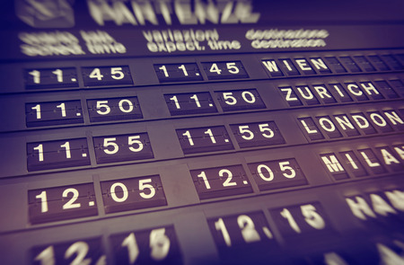 Illuminated departures board at an airport giving the flight details for upcoming flights and departures in a transport and travel conceptのeditorial素材