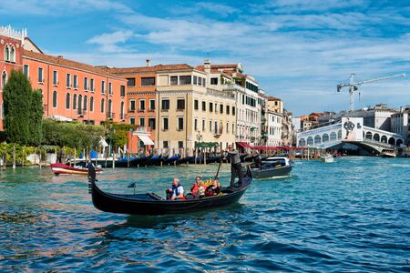 Tourists on a gondola on the Grand Canal in Venice with the Rialto bridge in the background in a travel and tourism conceptのeditorial素材