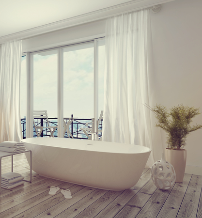 Modern stylish white bathroom interior with a free standing tub in front of floor-to-ceiling glass windows leading to a balcony, bright and airy daylight. 3d Rendering.の写真素材