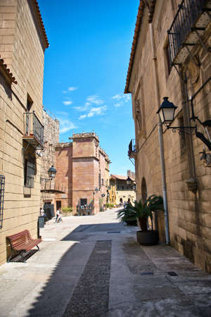 Deserted Street Scene and Traditional Architecture on Sunny Day with Blue Sky in Historical Poble Espanyol District, Barcelona, Spainの写真素材