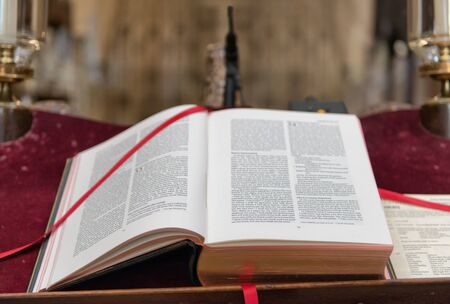 Close up of Christian Holy Bible Old Testament with red book marker on table laced around the topの写真素材