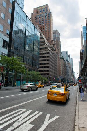 Rear View of Yellow Taxi Cab Driving in Dedicated Lane on Busy Street in Manhattan, New York City,...