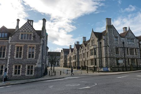 Medieval era historic brick and stone town buildings with street in foreground at Winchester, United Kingdomの写真素材