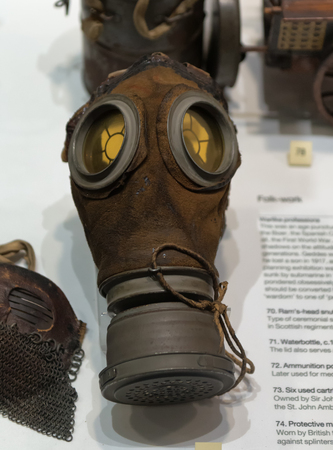 Single poisonous gas mask for soldier with other objects on display in case at museumのeditorial素材