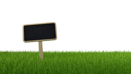 Blank slate signboard on a lush grassy meadow or lawn isolated on a white background with copy space, banner panoramaの写真素材
