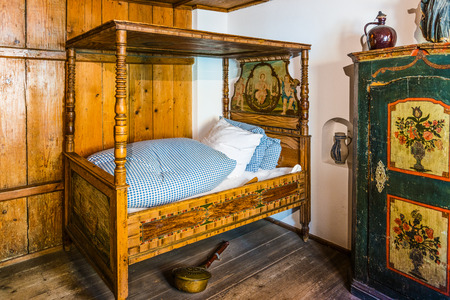 Augsburg, Germany - September 08, 2016: Historic architecture display of restored medieval era luxury bed in room with warming pot in the Fuggerei, Augsburg, Germanyのeditorial素材