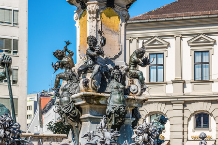 Bronze fountains with cherubs at the foot of the statue of the Emperor Augustus, Augsburg, Bavaria, Germanyのeditorial素材