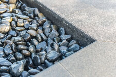 Close up view on concrete sidewalk with stones in corner section for concept about drainage and...