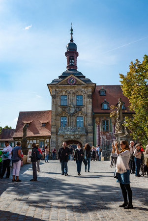Tourists on a cobbled street in Bamberg, Germany in front of the Old Town Hall built on an island in the Regnitz Riverのeditorial素材