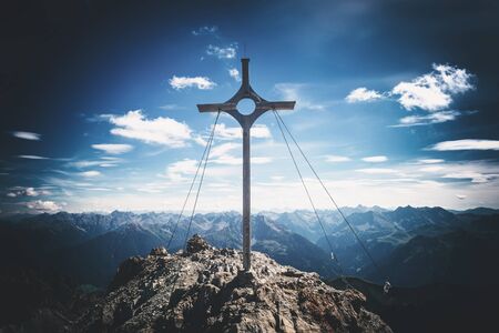 Summit marker on Grosser Krottenkopf, the highest peak in the Austrian Prealps, overlooking a vista of distant mountain ranges and a sign of sporting achievementの写真素材