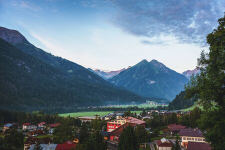 View of the Alpine skiing resort of Lech, Austria nestling in a forested valley surrounded by high mountain peaks and a popular tourist destination for winter sportのeditorial素材