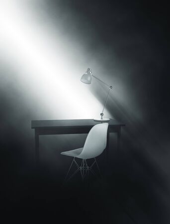 Shaft of sunlight falling penetrating the gloom illuminating a writing table with anglepoise lamp and molded modern chair throwing eerie shadows on the wall, 3d, render with copy spaceの写真素材