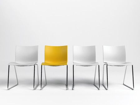 Line of three white and one yellow chairs against a white background with copy space in a conceptual image. 3d rendering.の写真素材