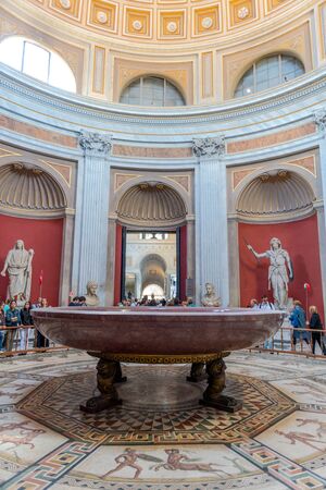 VATICAN, ITALY - Circa May, 2016: Hercules statue figure and round monolithic porphyry basin in Round Room of Pio-Clementino Museum in Vatican museums in Vatican cityのeditorial素材