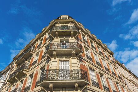 Corner angle of a historic townhouse with ornate wrought iron balconies and brick and stone...