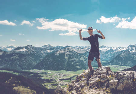 Man celebrating nature and reaching the summit in the Alps, Germanyの写真素材