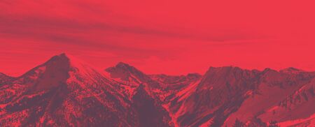 Bright red panoramic alpine landscape with artistic color effect over snowy winter mountain peaks and steep valleysの写真素材