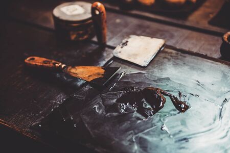 Closeup of putty knife on table with oil paintのeditorial素材