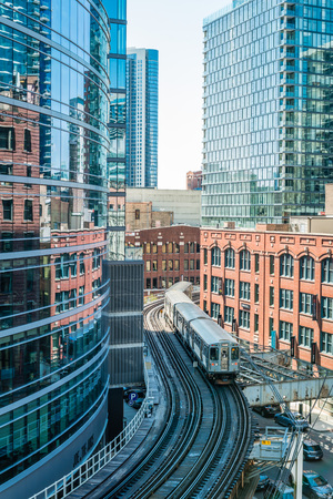 Moving Train on elevated tracks within buildings at the Loop between buildings in Chicago Downtown,...
