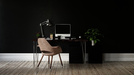 Monitor and desk lamp on black table with metal legs and brown chair on tan wood floor in front of completely black wallの写真素材