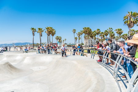 LOS ANGELES, USA - May 15 2018: Group of people standing at a skate park leaning on metal rails watching young men skateboarding in Santa Monica, Los Angeles, Californiaのeditorial素材