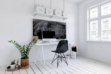 Trendy white office interior with blackboard above a small desk with computer and chair alongside potted plants. 3d renderingの写真素材