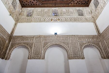SEVILLE, SPAIN - December 09 2019: Ornamented arches of the white walls of Patio Del Yeso in the old Arab Palace in Seville, Spainのeditorial素材