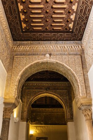 SEVILLE, SPAIN - December 09 2019: Ornamented arches and ceiling of the corridor inside the Royal Alcazars of Seville castle in Spain. Famous Andalusian architectureのeditorial素材