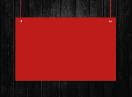 Red hanging sign with copy space for text on black Board background.の写真素材