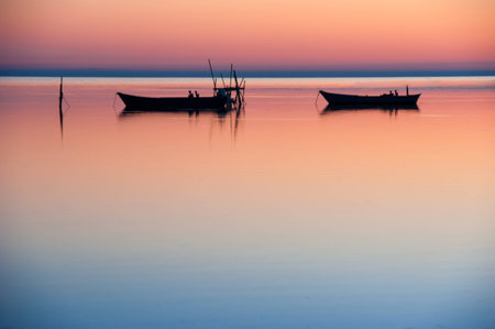 Fishing boats at sunsetの写真素材
