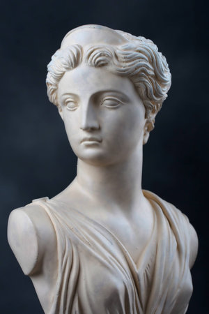 A copy of a stone bust of the Greek Goddess Artemis, daughter of Zeus, twin sister of Apollo   This photograph provides a 2 3 view of the face and has dramatic low key lighting のeditorial素材
