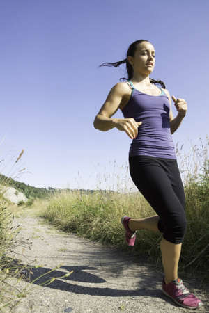 Low angle of young women running but coming to a stop 