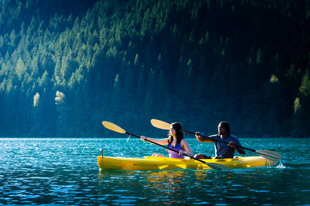 Couple paddling in kayak on lake.の写真素材