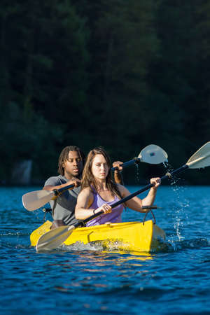 Couple paddling in kayak on lake.の写真素材