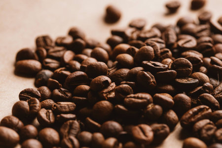 dark coffee beans close-up on light paper close up.の写真素材