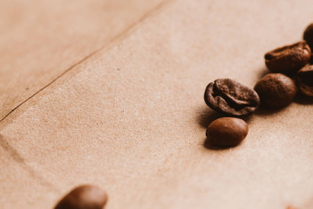 dark coffee beans close-up on light paper close up.