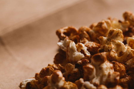 sweet caramel popcorn close-up on light paper.