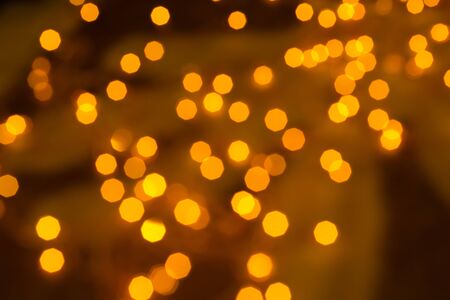 many defocused golden dots on a brown backgroundの写真素材