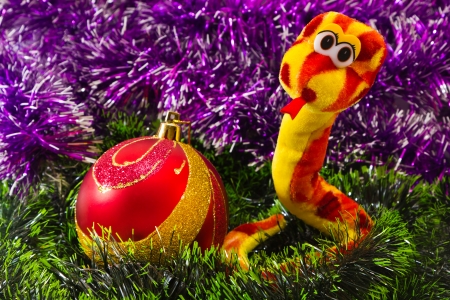 snake and Christmas balls on a green matの写真素材