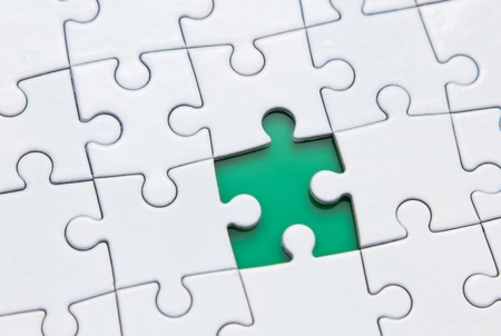 missing one piece of the puzzle on a green backgroundの写真素材
