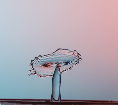 water drops falling onto the water surfaceの写真素材