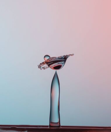 water drops falling onto the water surfaceの写真素材