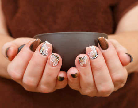 Cup in hand with manicureの写真素材