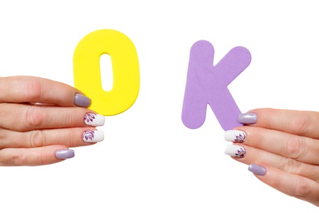 Hands of woman with manicure hold letters okの写真素材
