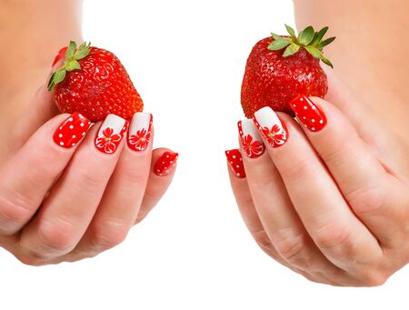 strawberries on a saucer in a female hand with a manicure on a white backgroundの写真素材
