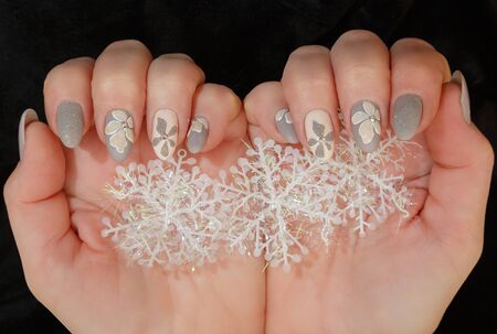 Female hands with a multicolored manicure and snowflakes closeupの写真素材