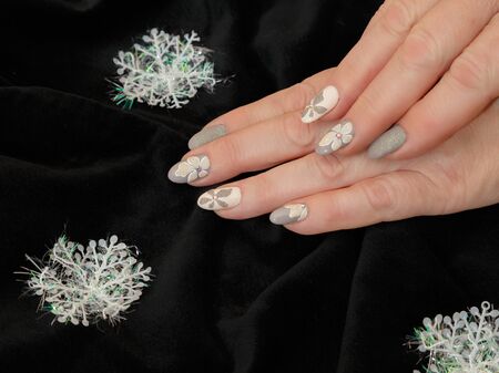 Female hands with a multicolored manicure and snowflakes closeupの写真素材