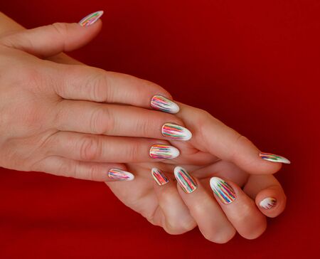 Female hands with a multicolored manicure closeupの写真素材