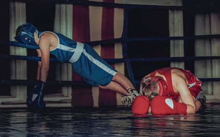 Two teenage boxers in the ring have a rest after hard training.の写真素材