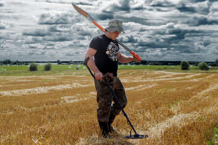 Search for treasure in the field with a device and a shovel